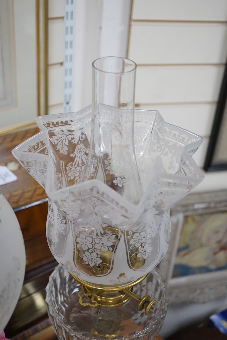 Three Victorian brass column oil lamps, with original brass fittings, glass reservoirs and shades. Tallest 72cm high.